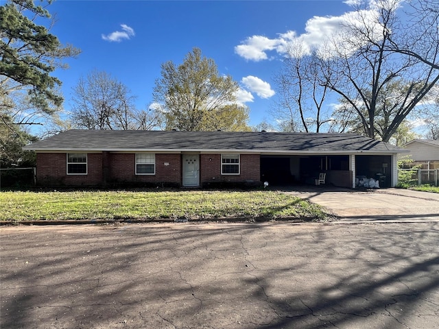 single story home with an attached carport, a front yard, fence, and concrete driveway