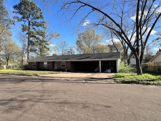 exterior space with a carport, driveway, and fence