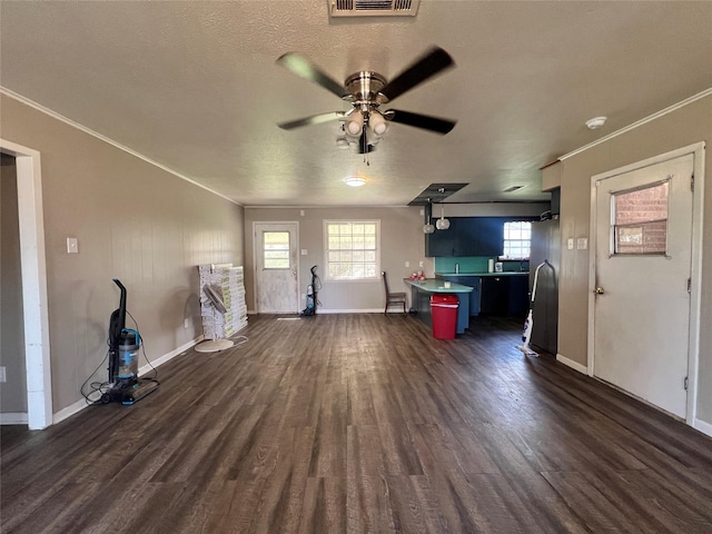 unfurnished living room featuring dark wood-style floors, a textured ceiling, ornamental molding, and a ceiling fan