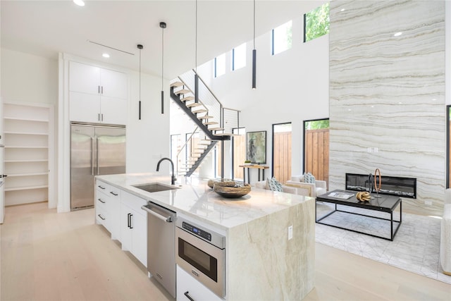 4218 Bonham St, Dallas, TX 75229 - kitchen with appliances with stainless steel finishes, a sink, light stone counters, modern cabinets, and recessed lighting
