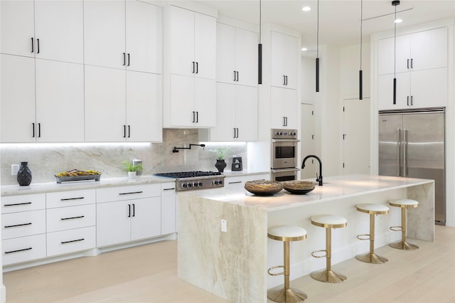4218 Bonham St, Dallas, TX 75229 - kitchen with appliances with stainless steel finishes, a breakfast bar, tasteful backsplash, white cabinets, and recessed lighting