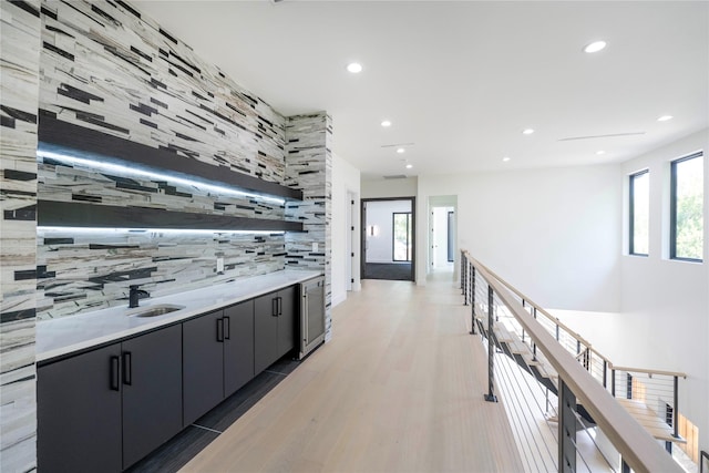 4218 Bonham St, Dallas, TX 75229 - hallway featuring wine cooler, light wood-style floors, recessed lighting, an upstairs landing, and a sink