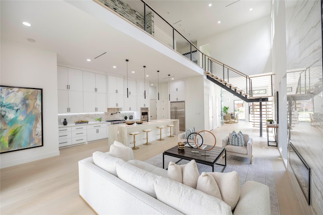 4218 Bonham St, Dallas, TX 75229 - living room featuring a high ceiling, light wood-style flooring, stairs, and recessed lighting