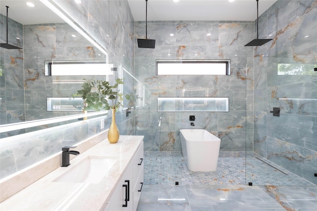 4218 Bonham St, Dallas, TX 75229 - bathroom featuring tile walls, a walk in shower, vanity, a freestanding tub, and recessed lighting