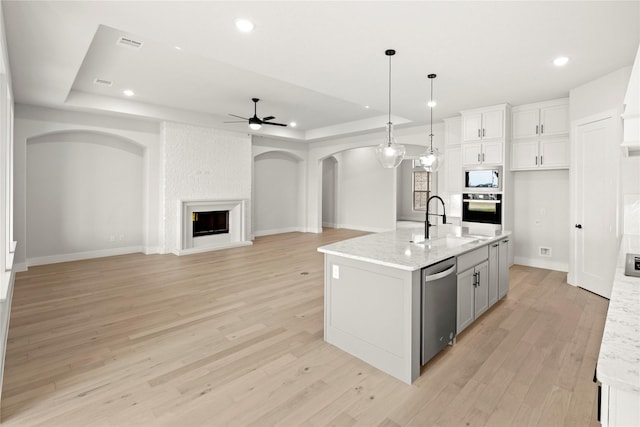 160 Waterview Dr, Gunter, TX 75058 - kitchen featuring a sink, black oven, built in microwave, a tray ceiling, and arched walkways