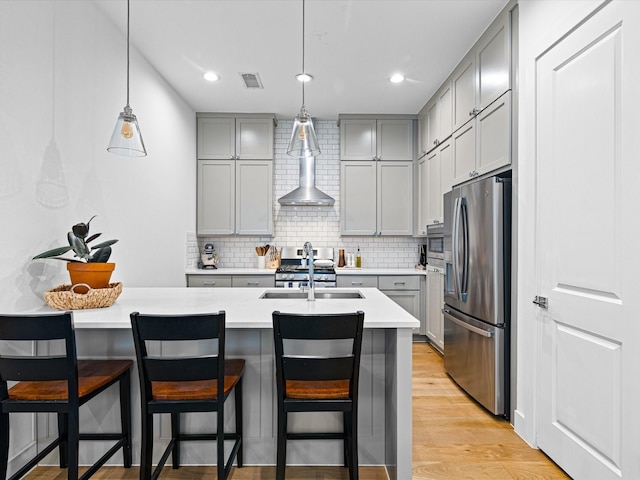 kitchen featuring a sink, light countertops, stainless steel appliances, gray cabinets, and light wood-style flooring