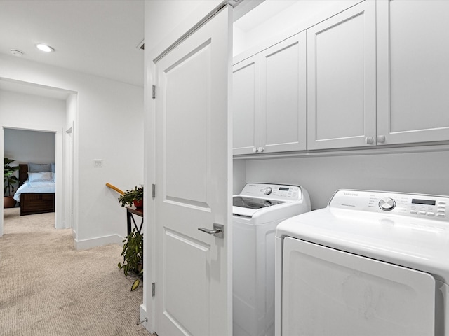 laundry area with light colored carpet, recessed lighting, baseboards, cabinet space, and washer and clothes dryer