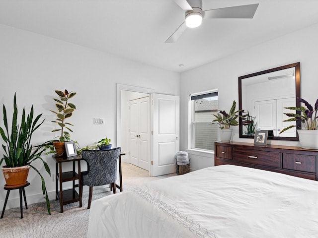 bedroom featuring light colored carpet, baseboards, and a ceiling fan