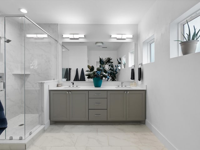 full bath featuring double vanity, marble finish floor, a sink, and a marble finish shower