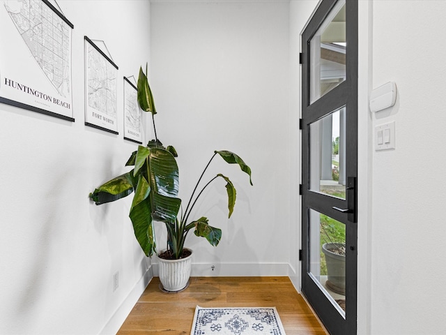 foyer featuring baseboards and wood finished floors