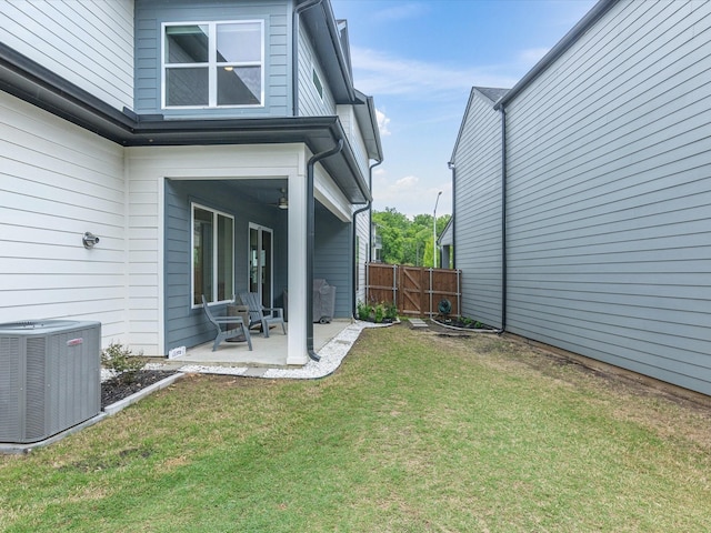 view of yard featuring central AC unit, a gate, fence, and a patio