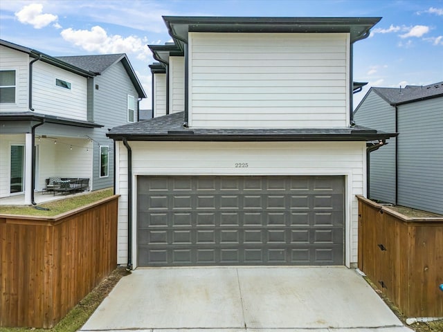 garage featuring fence and driveway