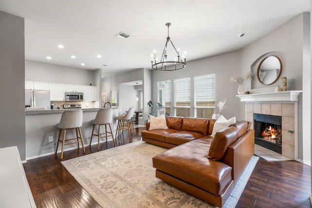9836 Old Field Dr, Mckinney, TX 75072 - living room featuring dark wood-style flooring, recessed lighting, a chandelier, and a tiled fireplace