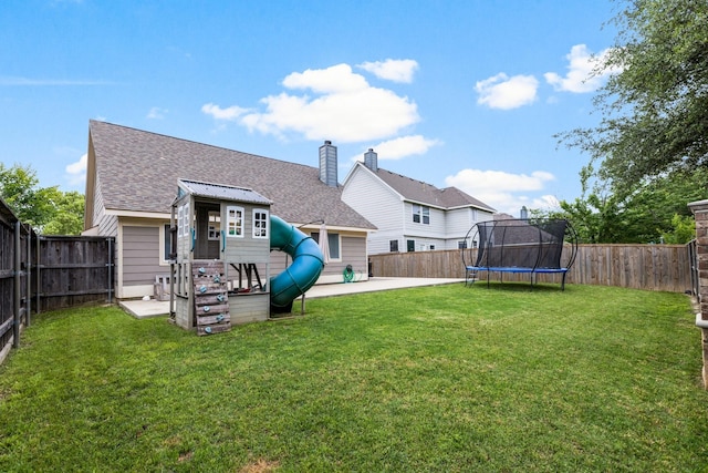 9836 Old Field Dr, Mckinney, TX 75072 - back of house featuring roof with shingles, a fenced backyard, a patio area, and a trampoline