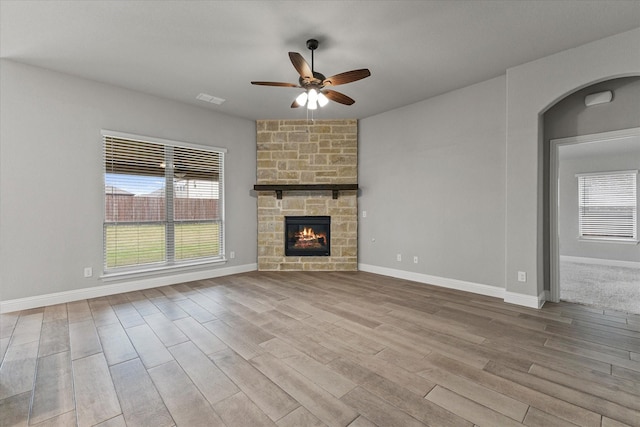 5010 Huffines Blvd, Royse City, TX 75189 - unfurnished living room featuring wood finished floors, a ceiling fan, visible vents, and a stone fireplace