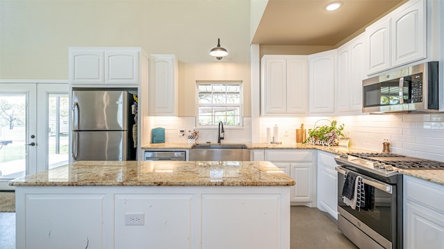 kitchen featuring a center island, a sink, light stone countertops, and stainless steel appliances