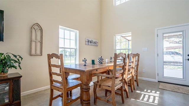 dining room with baseboards, finished concrete flooring, and a wealth of natural light