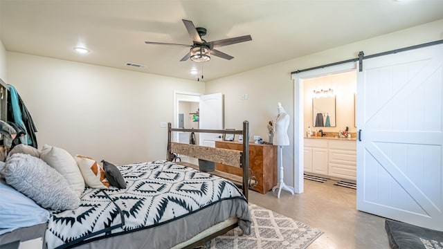 bedroom featuring a barn door, concrete floors, recessed lighting, ensuite bathroom, and visible vents
