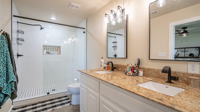 bathroom with visible vents, a tile shower, and a sink