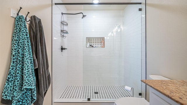 bathroom with vanity, toilet, and a shower stall