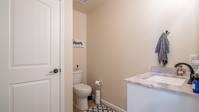 half bath with toilet, baseboards, tile patterned flooring, and vanity