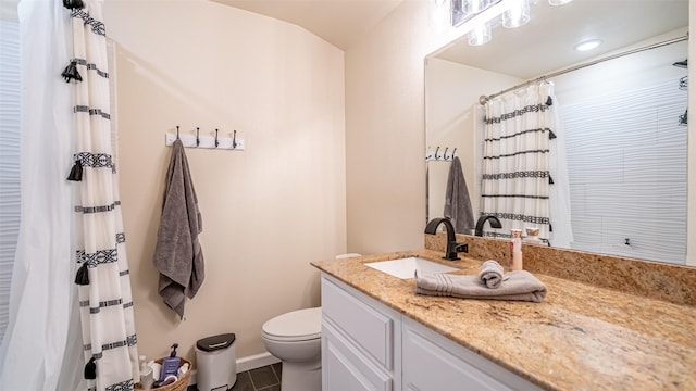 half bath with baseboards, tile patterned flooring, vanity, and toilet