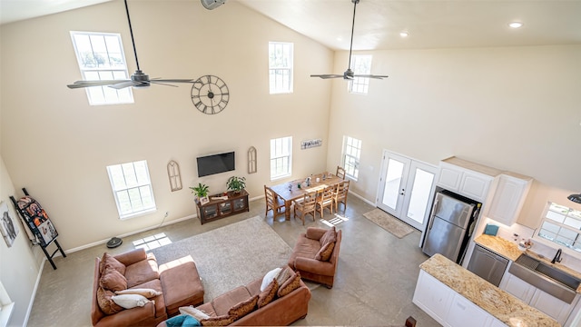 living area with baseboards, recessed lighting, ceiling fan, and high vaulted ceiling