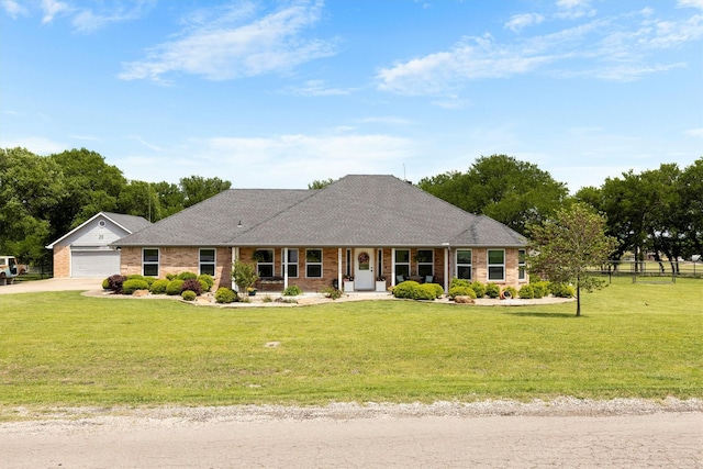 single story home with a garage, a front yard, driveway, and covered porch