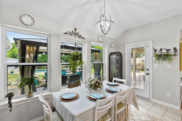 dining space featuring an inviting chandelier, vaulted ceiling, light tile patterned floors, baseboards, and a textured ceiling
