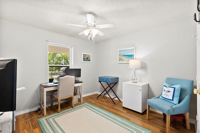 office area featuring baseboards, a ceiling fan, wood finished floors, and a textured ceiling