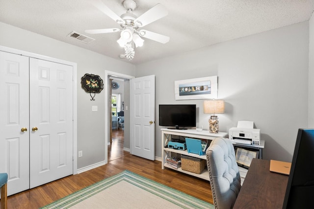 office space with wood finished floors, visible vents, baseboards, a textured ceiling, and ceiling fan