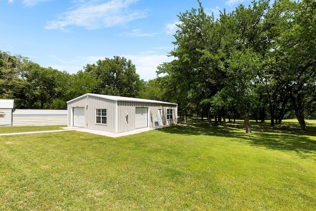 exterior space with an outdoor structure, a detached garage, and fence