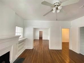 unfurnished living room featuring a ceiling fan and dark wood-style floors