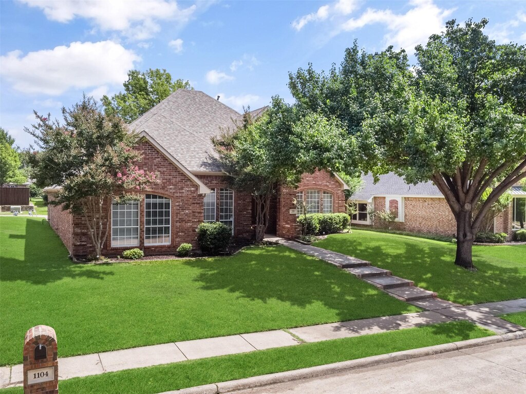 1104 Shadetree Ln, Allen, TX 75013 - traditional-style home featuring brick siding, french doors, roof with shingles, and a front lawn