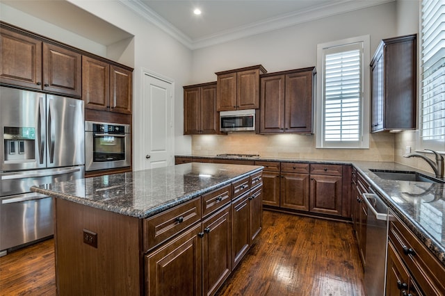 2110 Helsminster Dr, Dallas, TX 75201 - kitchen featuring appliances with stainless steel finishes, a sink, a center island, dark stone countertops, and crown molding