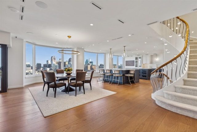 dining space with visible vents, recessed lighting, wood-type flooring, and stairs