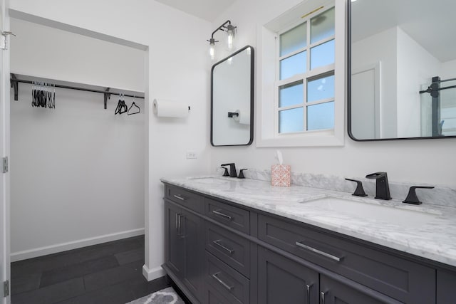 909 Crockett St, Santa Anna, TX 76878 - full bathroom featuring a walk in closet, double vanity, baseboards, and a sink