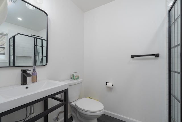 909 Crockett St, Santa Anna, TX 76878 - full bathroom featuring a sink, toilet, a stall shower, and baseboards