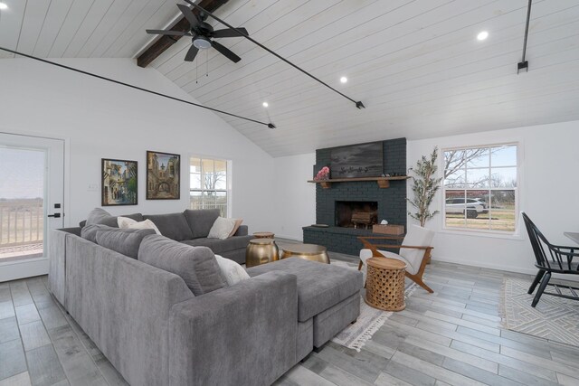 909 Crockett St, Santa Anna, TX 76878 - living room featuring a brick fireplace, a ceiling fan, recessed lighting, light wood-style flooring, and vaulted ceiling with beams