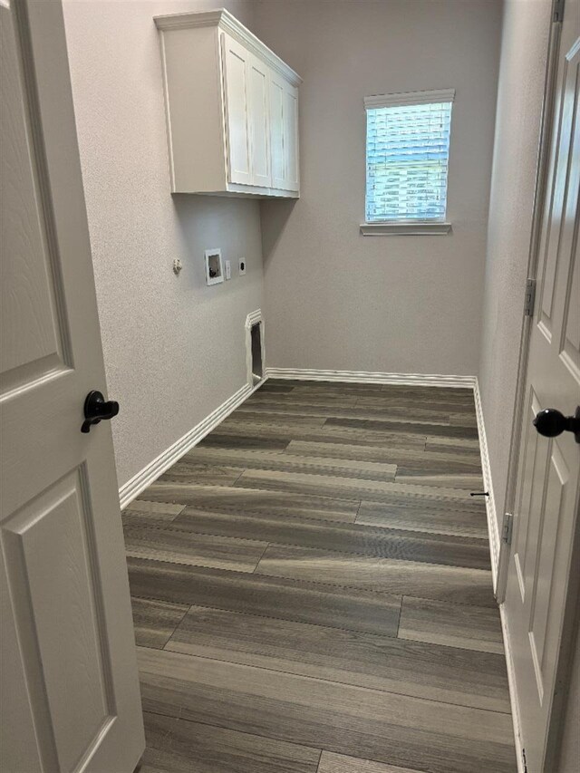 clothes washing area with dark wood-style flooring, electric dryer hookup, baseboards, hookup for a gas dryer, and washer hookup