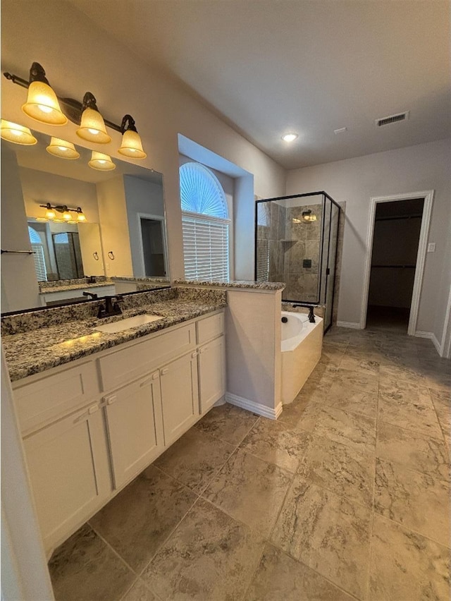 full bathroom with vanity, baseboards, a shower stall, visible vents, and a garden tub