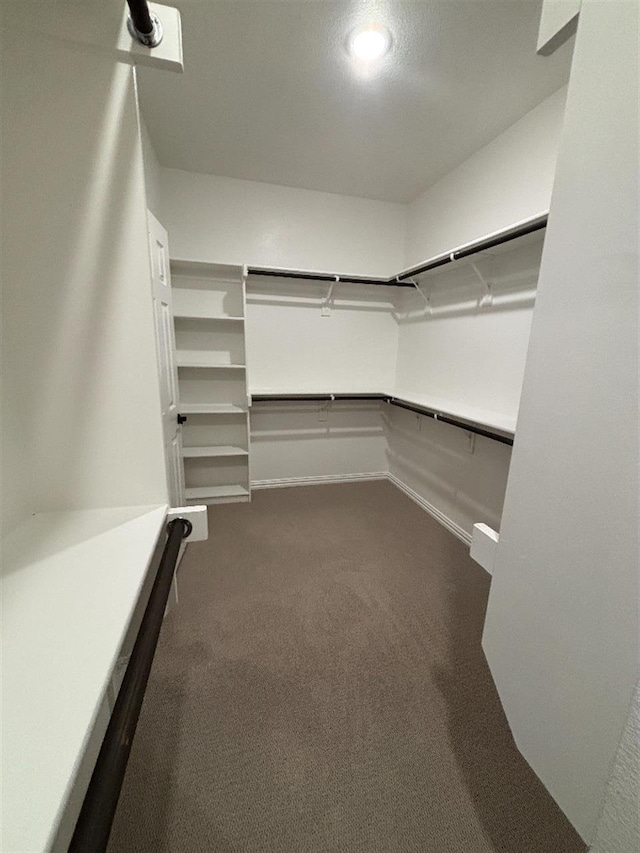 spacious closet featuring dark carpet