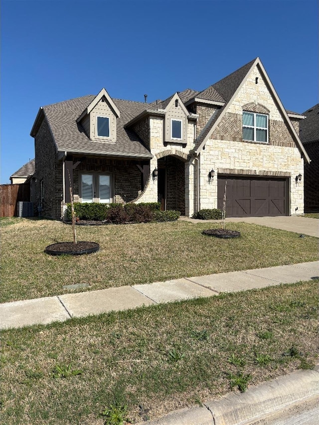 view of front facade featuring concrete driveway, central air condition unit, an attached garage, and a front lawn