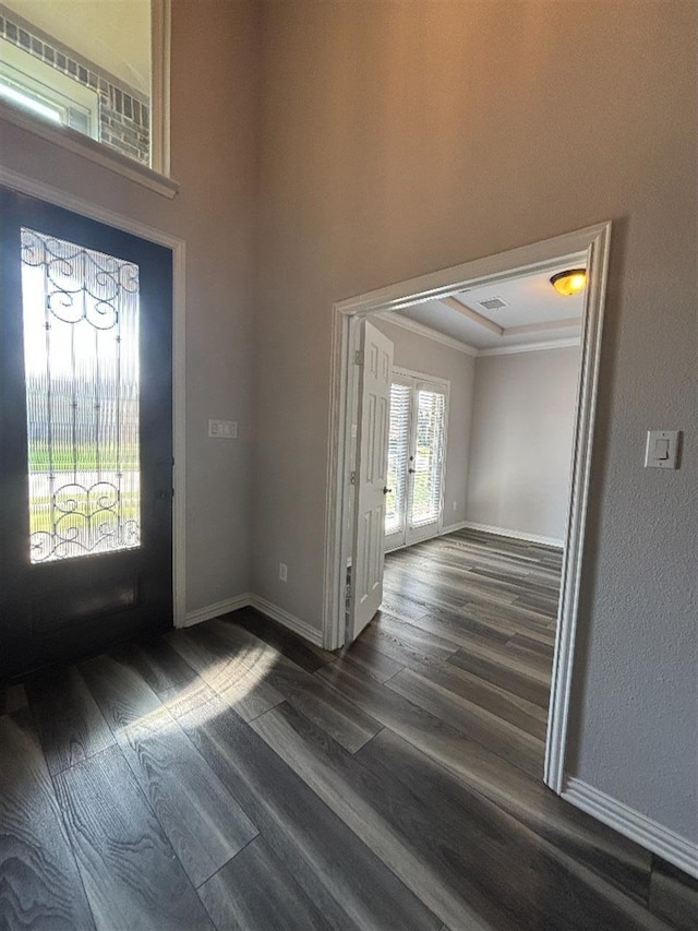 foyer with dark wood-type flooring, french doors, baseboards, and crown molding