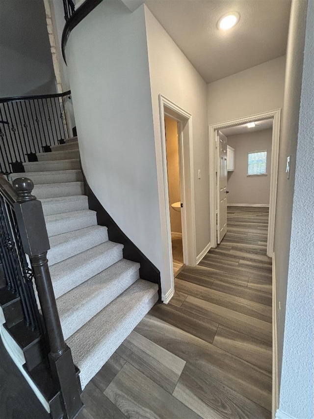 stairway featuring baseboards and wood finished floors