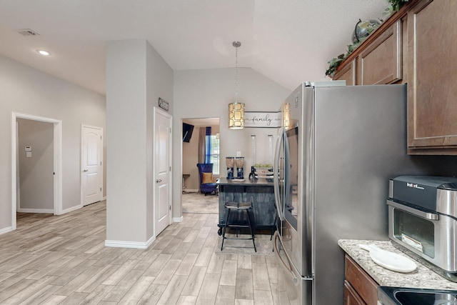 510 Springtime Dr, Cedar Hill, TX 75104 - kitchen with light wood-style flooring, freestanding refrigerator, vaulted ceiling, baseboards, and brown cabinetry