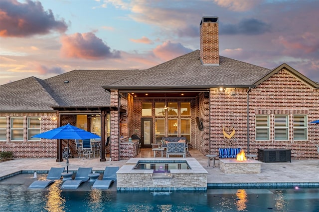 431 Lakepoint Cir, Prosper, TX 75078 - back of property at dusk with an outdoor fire pit, an outdoor pool, brick siding, and a patio