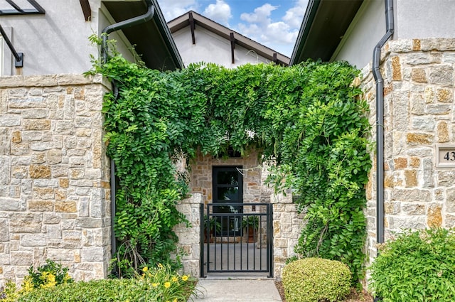 431 Lakepoint Cir, Prosper, TX 75078 - entrance to property featuring stone siding, stucco siding, and a gate