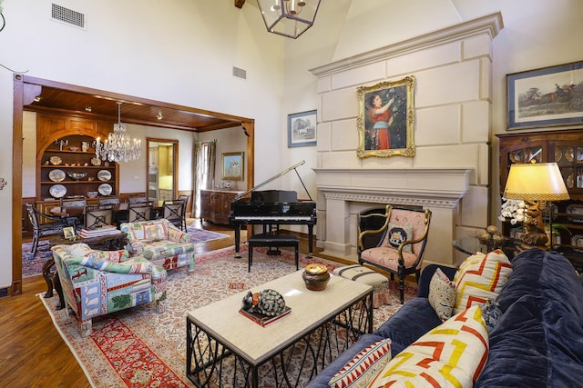 3636 Amherst Ave, University Park, TX 75225 - living room with visible vents, a chandelier, a towering ceiling, wood finished floors, and a fireplace