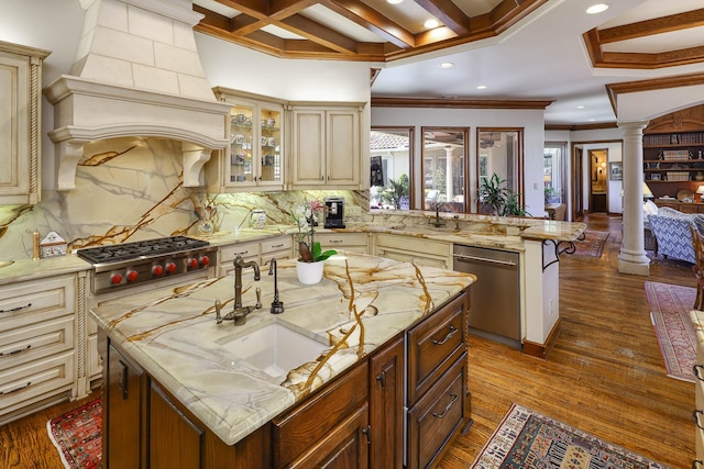 3636 Amherst Ave, University Park, TX 75225 - kitchen with a peninsula, ornate columns, a sink, cream cabinetry, and appliances with stainless steel finishes